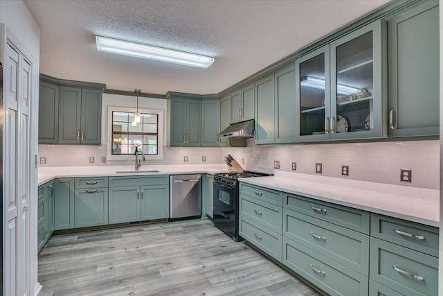 kitchen featuring black range with gas stovetop, stainless steel dishwasher, green cabinets, and sink