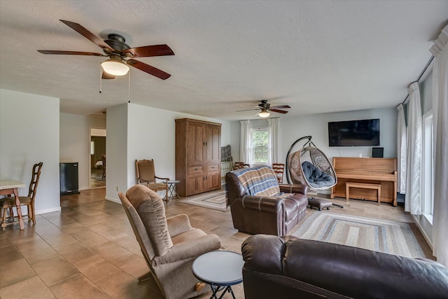 tiled living room with a textured ceiling and ceiling fan