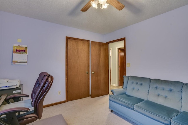 carpeted office with ceiling fan and a textured ceiling