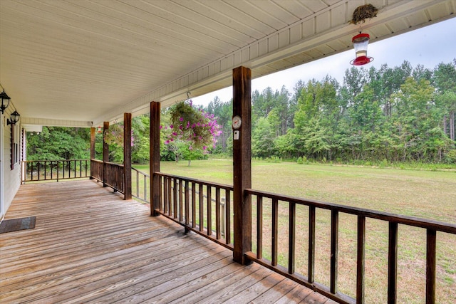 wooden deck with a lawn and covered porch