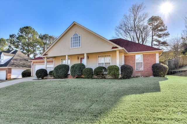 view of front of home featuring a garage, covered porch, and a front yard