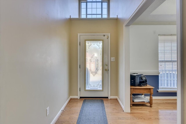 entryway featuring ornamental molding, plenty of natural light, and light hardwood / wood-style flooring