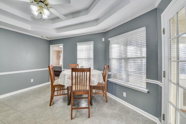 dining room with ornamental molding, light tile patterned floors, ceiling fan, and a tray ceiling