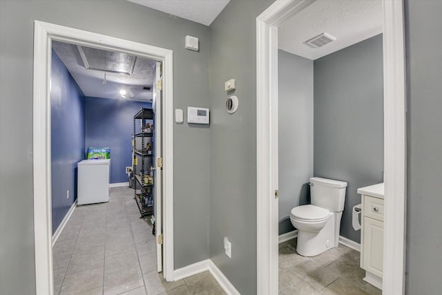 bathroom with vanity, tile patterned flooring, a textured ceiling, and toilet