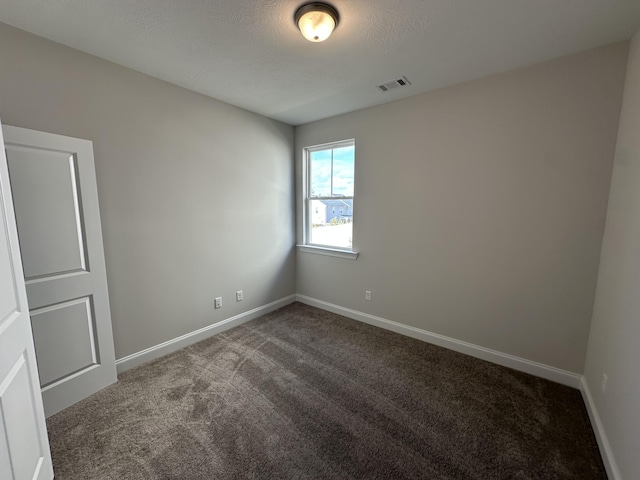 carpeted spare room with a textured ceiling