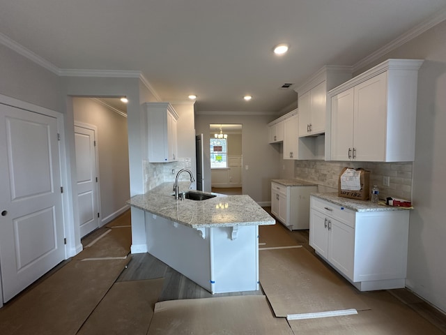 kitchen featuring sink, light stone counters, ornamental molding, decorative backsplash, and white cabinets