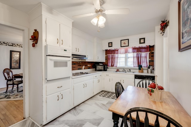 kitchen featuring sink, ceiling fan, white cabinets, white appliances, and backsplash