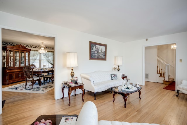 living room with hardwood / wood-style flooring and an inviting chandelier