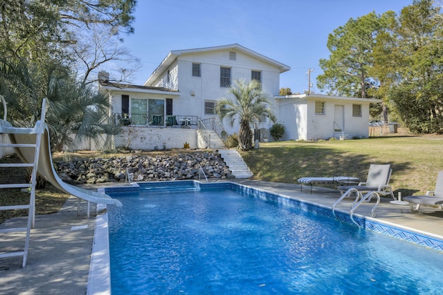 view of pool featuring a water slide, a yard, and a patio area