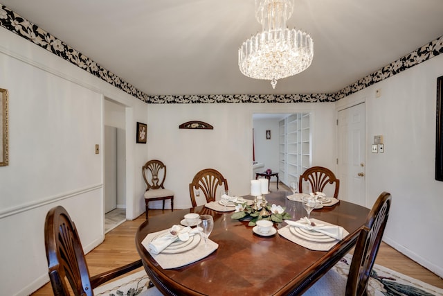 dining room featuring light wood-type flooring and an inviting chandelier