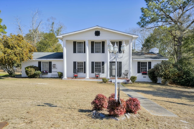 greek revival inspired property featuring a front yard