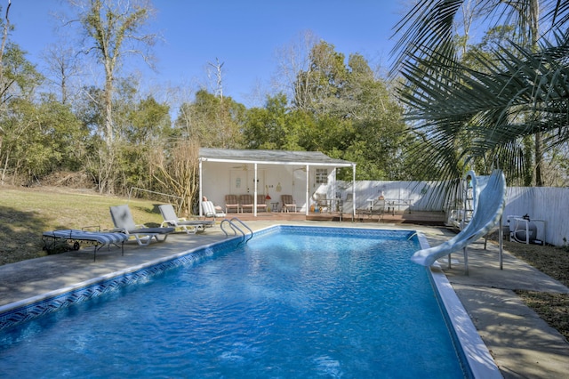 view of swimming pool with a water slide and a patio area