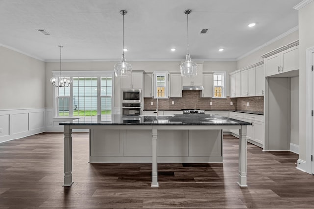 1216 Elbron Dr, Augusta, GA 30909 - kitchen with stainless steel appliances, a breakfast bar area, decorative backsplash, ornamental molding, and an island with sink