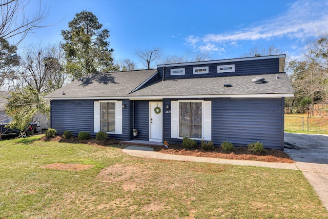 mid-century modern home featuring a front lawn and roof with shingles