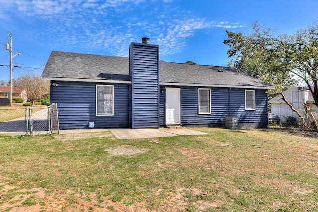 rear view of house with a gate, a patio, fence, a yard, and a chimney