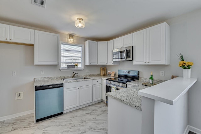 kitchen with visible vents, a peninsula, a sink, appliances with stainless steel finishes, and marble finish floor