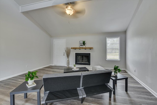 living area featuring wood finished floors, a fireplace, baseboards, and lofted ceiling