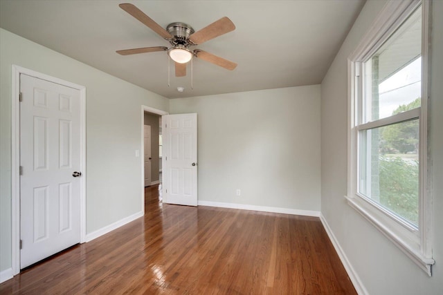 unfurnished bedroom with ceiling fan and dark wood-type flooring