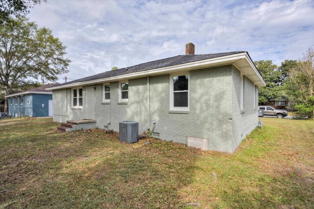 rear view of house featuring a yard and cooling unit