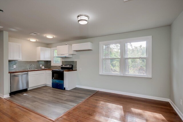 kitchen featuring white cabinets, hardwood / wood-style floors, stainless steel dishwasher, and range with electric stovetop