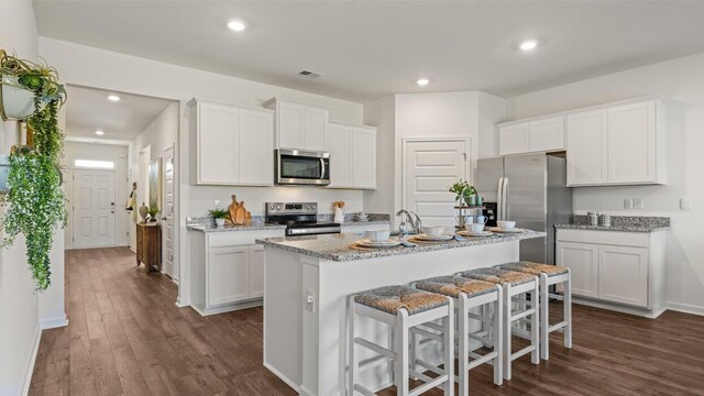 1260 Birch Cir, Grovetown, GA 30813 - kitchen featuring stainless steel appliances, dark wood-style flooring, a kitchen island with sink, white cabinetry, and recessed lighting