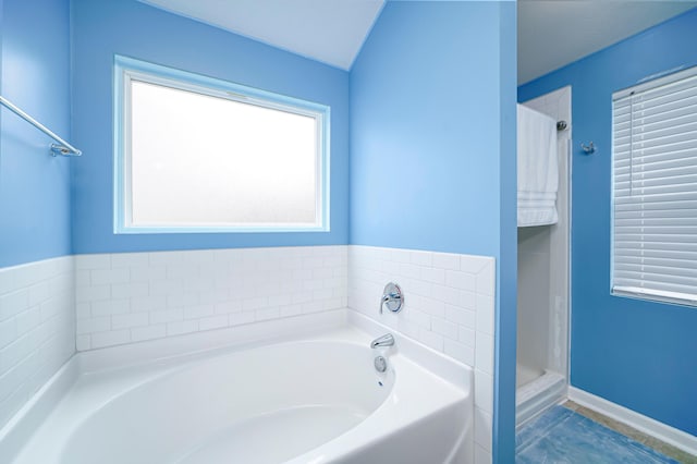 bathroom featuring shower with separate bathtub