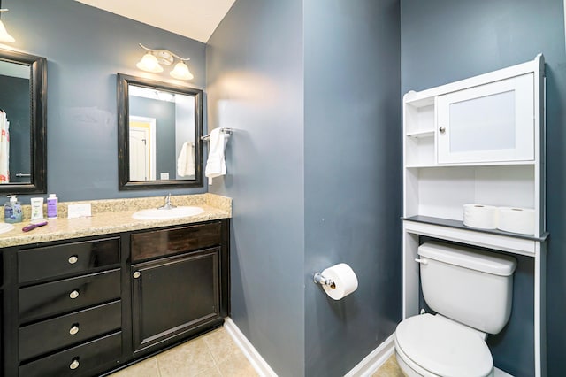 bathroom with tile patterned flooring, vanity, and toilet