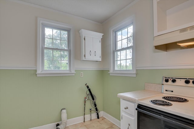 538 Hickman Rd, Augusta, GA 30904 - kitchen with range with electric cooktop, plenty of natural light, light countertops, white cabinets, and a wainscoted wall