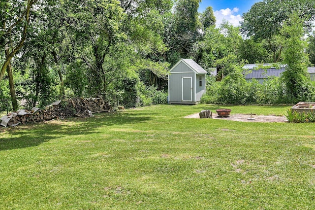 538 Hickman Rd, Augusta, GA 30904 - view of green lawn with an outdoor fire pit, a storage unit, and view of wooded area