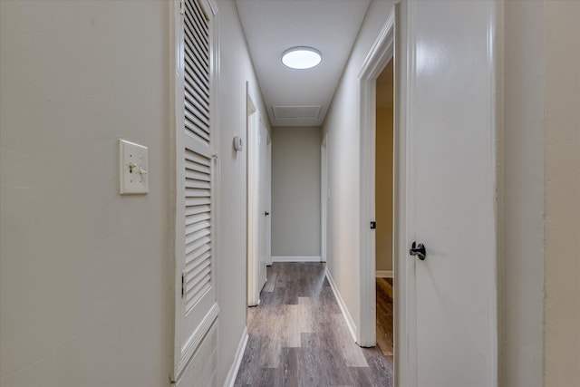 corridor featuring baseboards and wood finished floors