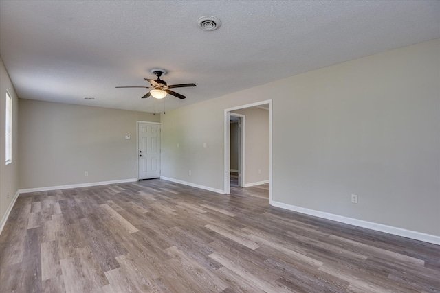 unfurnished room featuring a ceiling fan, wood finished floors, and baseboards