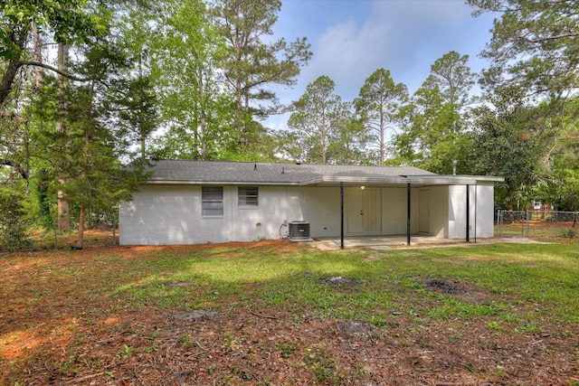 back of property featuring central air condition unit, a patio area, a yard, brick siding, and fence