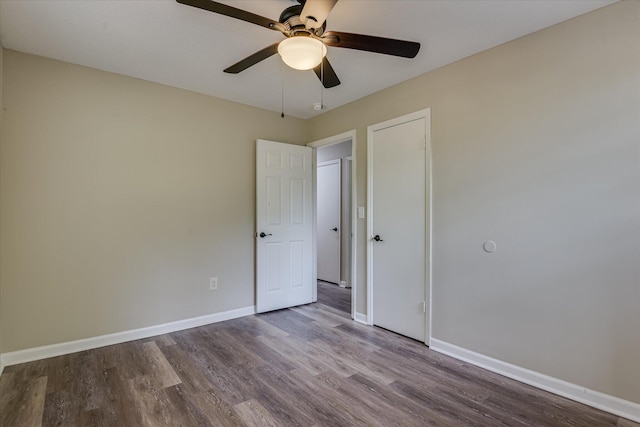 unfurnished bedroom featuring a ceiling fan, wood finished floors, and baseboards