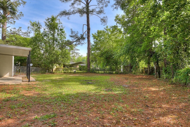 view of yard featuring fence and a carport