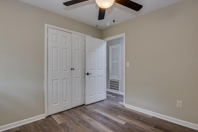 unfurnished bedroom featuring wood finished floors, a closet, a ceiling fan, and baseboards