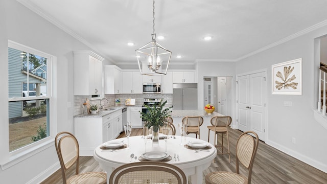 dining room featuring a wealth of natural light, baseboards, light wood finished floors, and ornamental molding