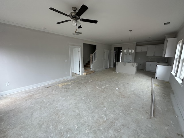 unfurnished living room featuring visible vents, a ceiling fan, crown molding, baseboards, and stairs