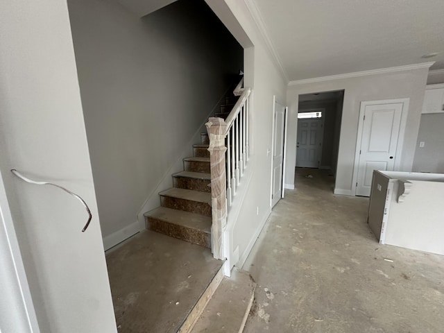 stairs with unfinished concrete floors, baseboards, and ornamental molding