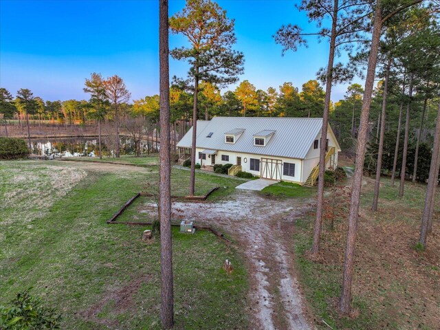 exterior space with a lawn, driveway, and metal roof