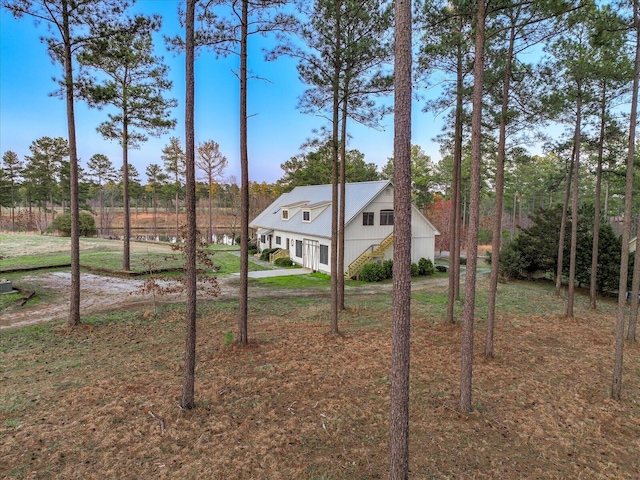 view of front of property featuring stairs and a front lawn