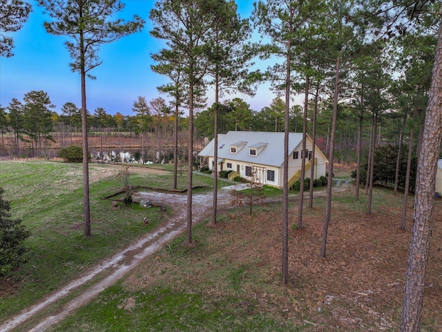 exterior space with driveway, a front lawn, and a water view