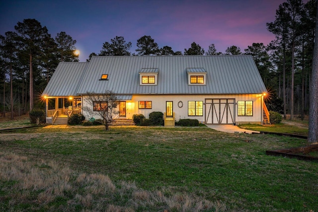 view of front of property featuring a standing seam roof, a lawn, and metal roof