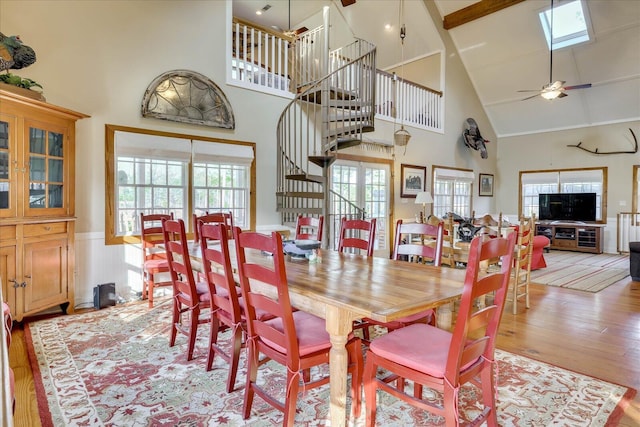 dining room with a wealth of natural light, wainscoting, a ceiling fan, and wood finished floors