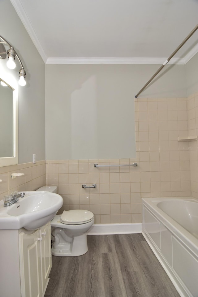 full bathroom with tile walls, hardwood / wood-style floors, toilet, bathtub / shower combination, and ornamental molding