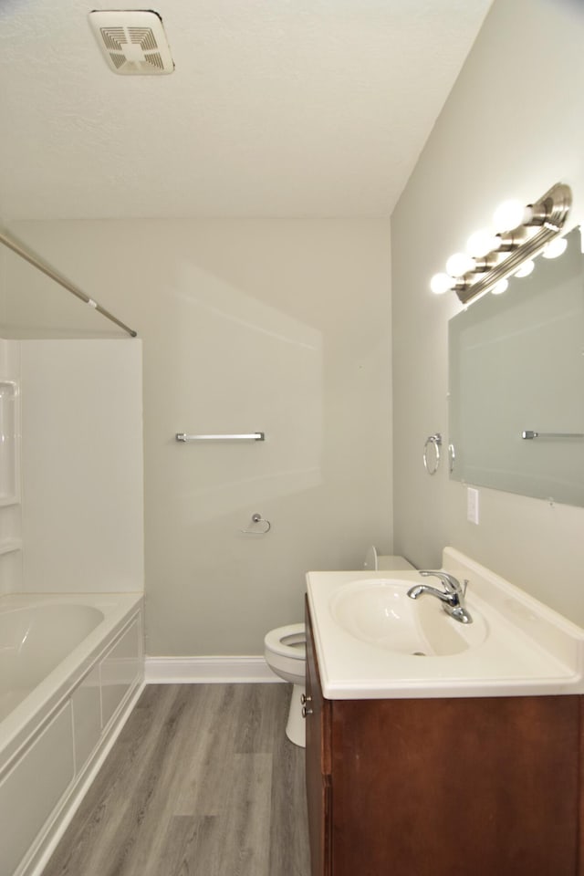 bathroom with hardwood / wood-style floors, vanity, and toilet