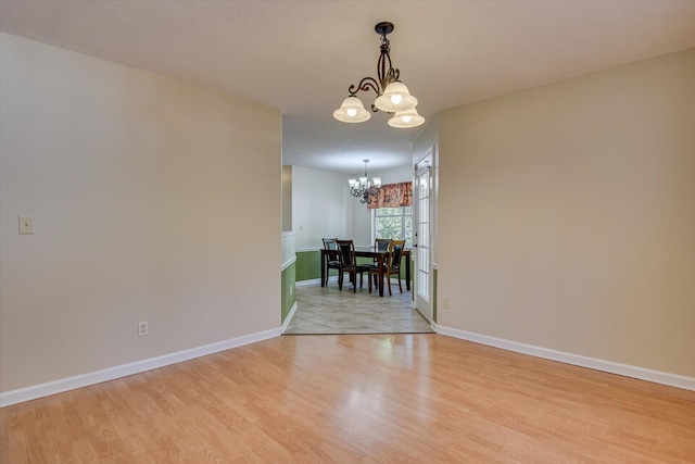 unfurnished dining area with light hardwood / wood-style flooring and an inviting chandelier