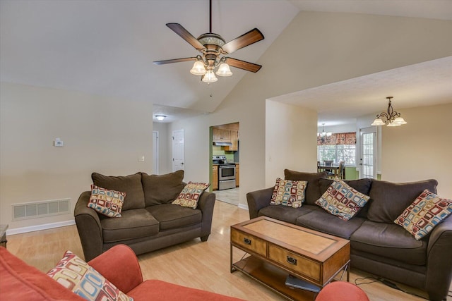 living room featuring ceiling fan with notable chandelier, light wood-type flooring, and high vaulted ceiling