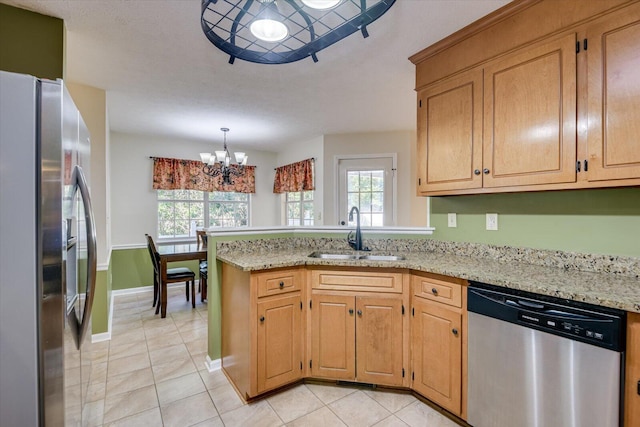 kitchen with sink, an inviting chandelier, kitchen peninsula, light tile patterned floors, and appliances with stainless steel finishes