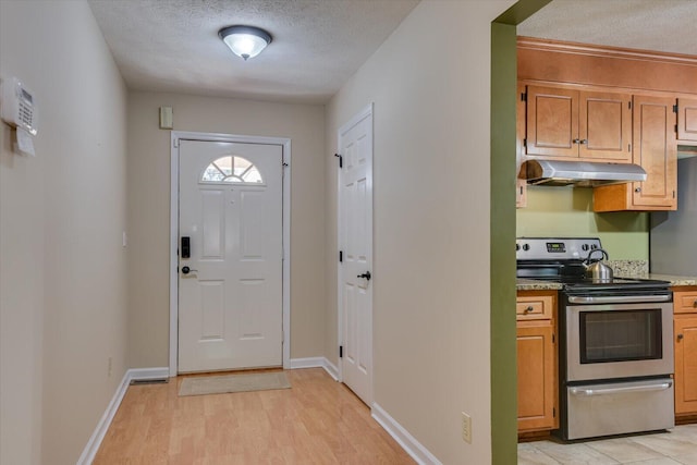 entryway with a textured ceiling and light hardwood / wood-style flooring