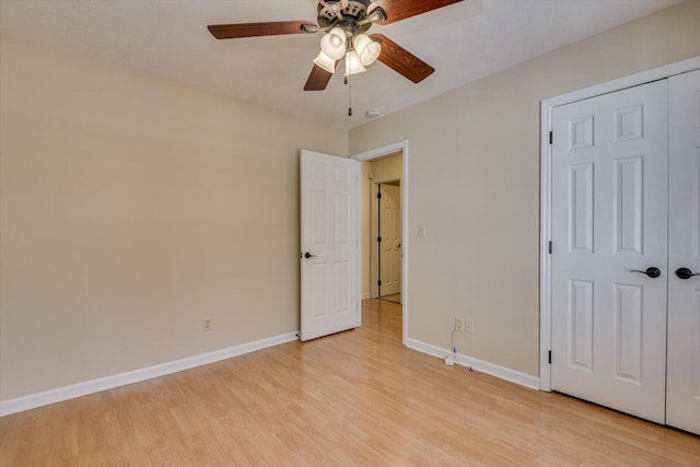 unfurnished bedroom with a closet, light hardwood / wood-style floors, and ceiling fan